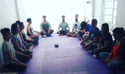 Pessoas sentadas meditando confortavelmente